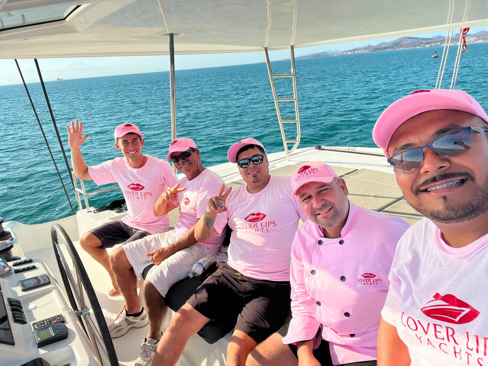 Lover Lips Yachts crew in pink uniforms delivering Pink Glove Service aboard the catamaran