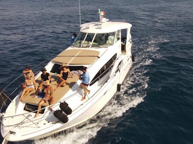Aerial view of Cabo2Vegas cruising with guests relaxing on the bow sun pad