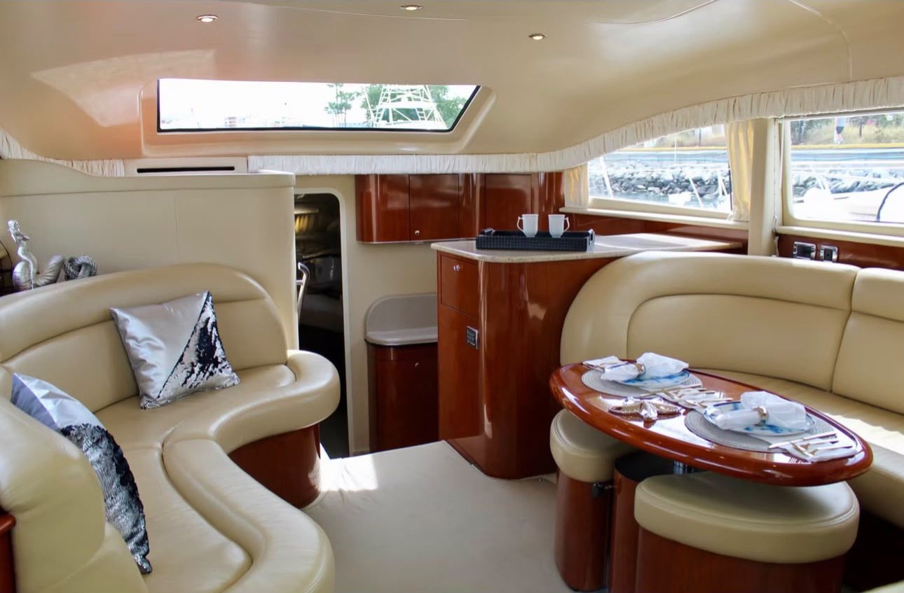 Interior salon of Cabo2Vegas with cream leather seating and a polished wood dining table