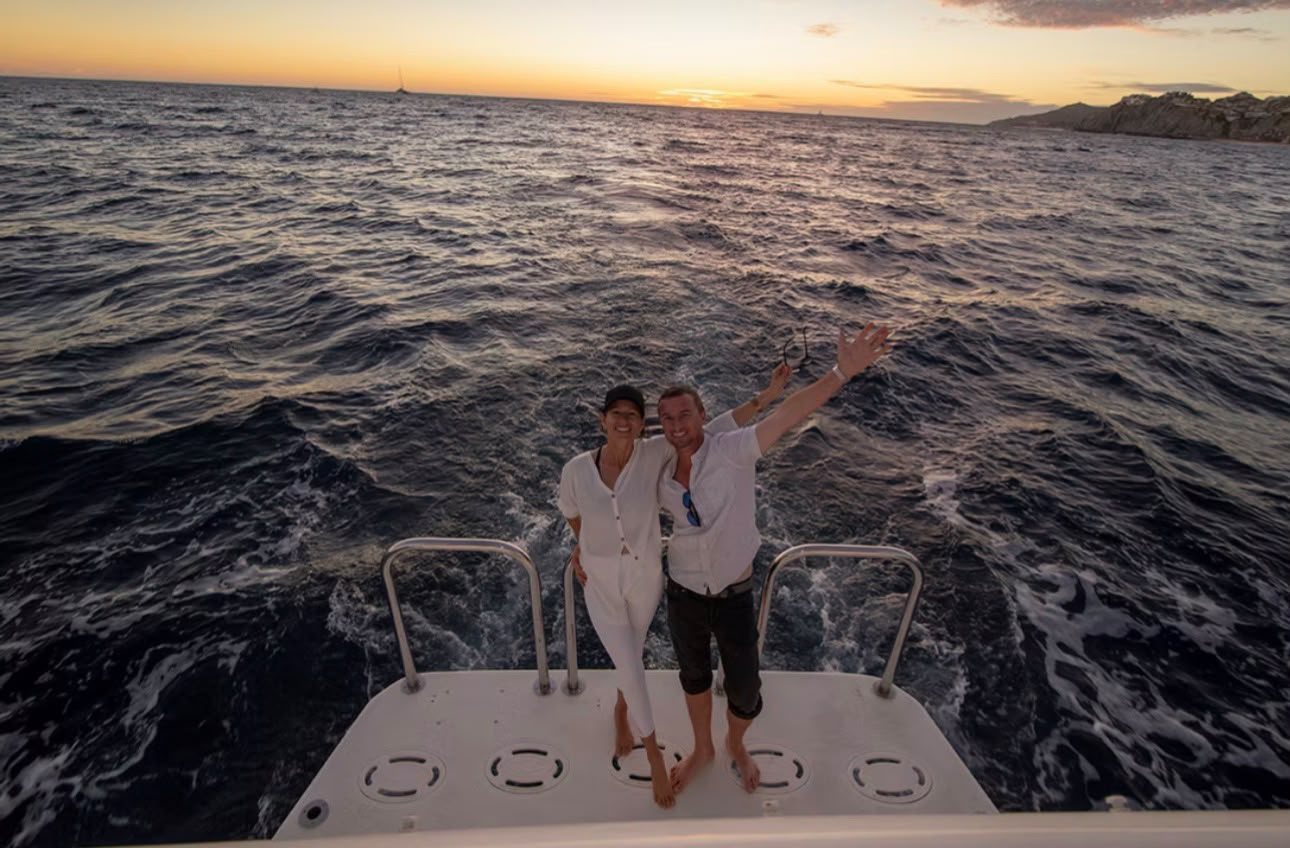 Couple celebrating at sunset on the Cabo2Vegas swim platform